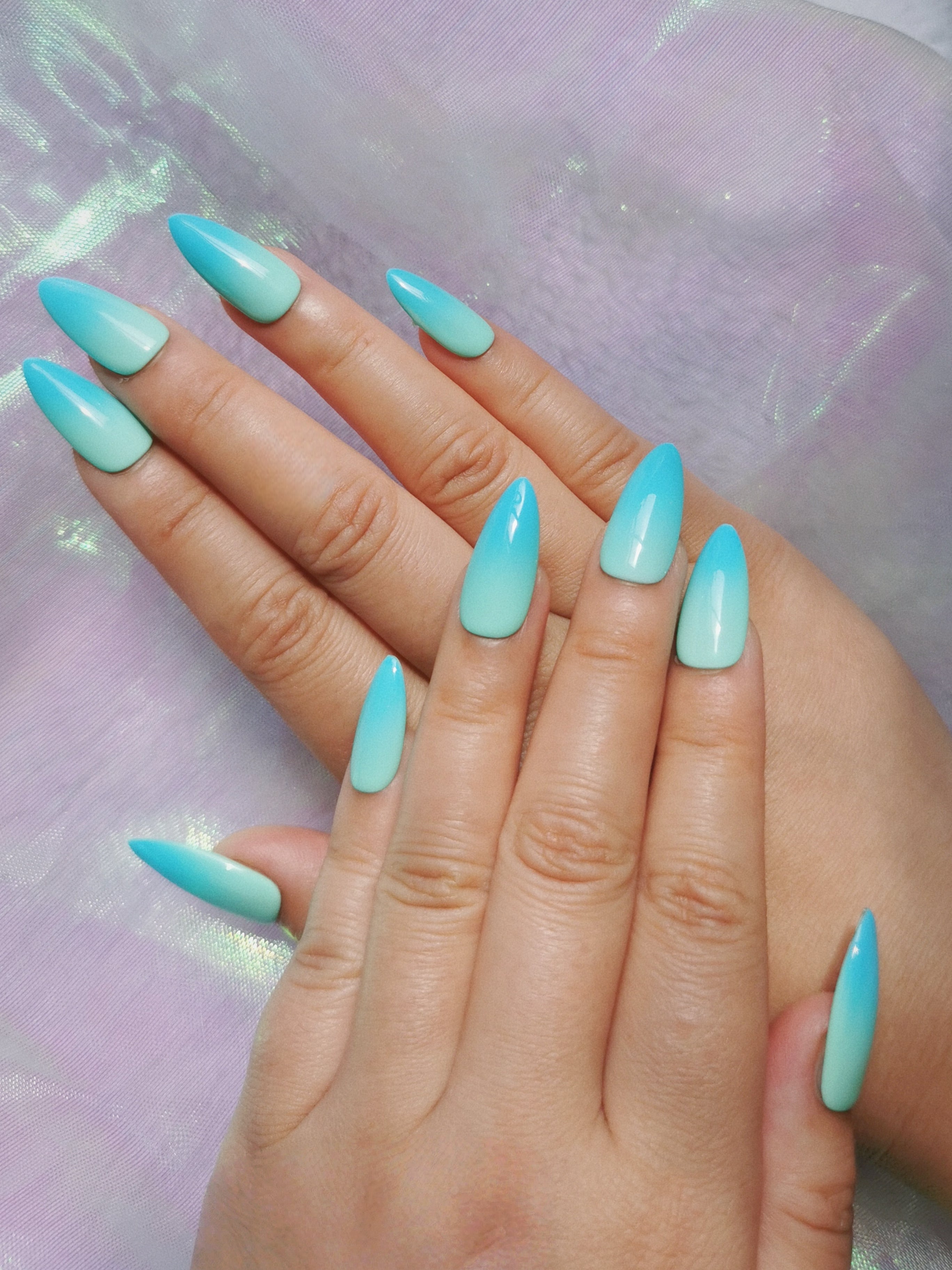 Mint blue ombre almond nails displayed with a glossy gradient finish