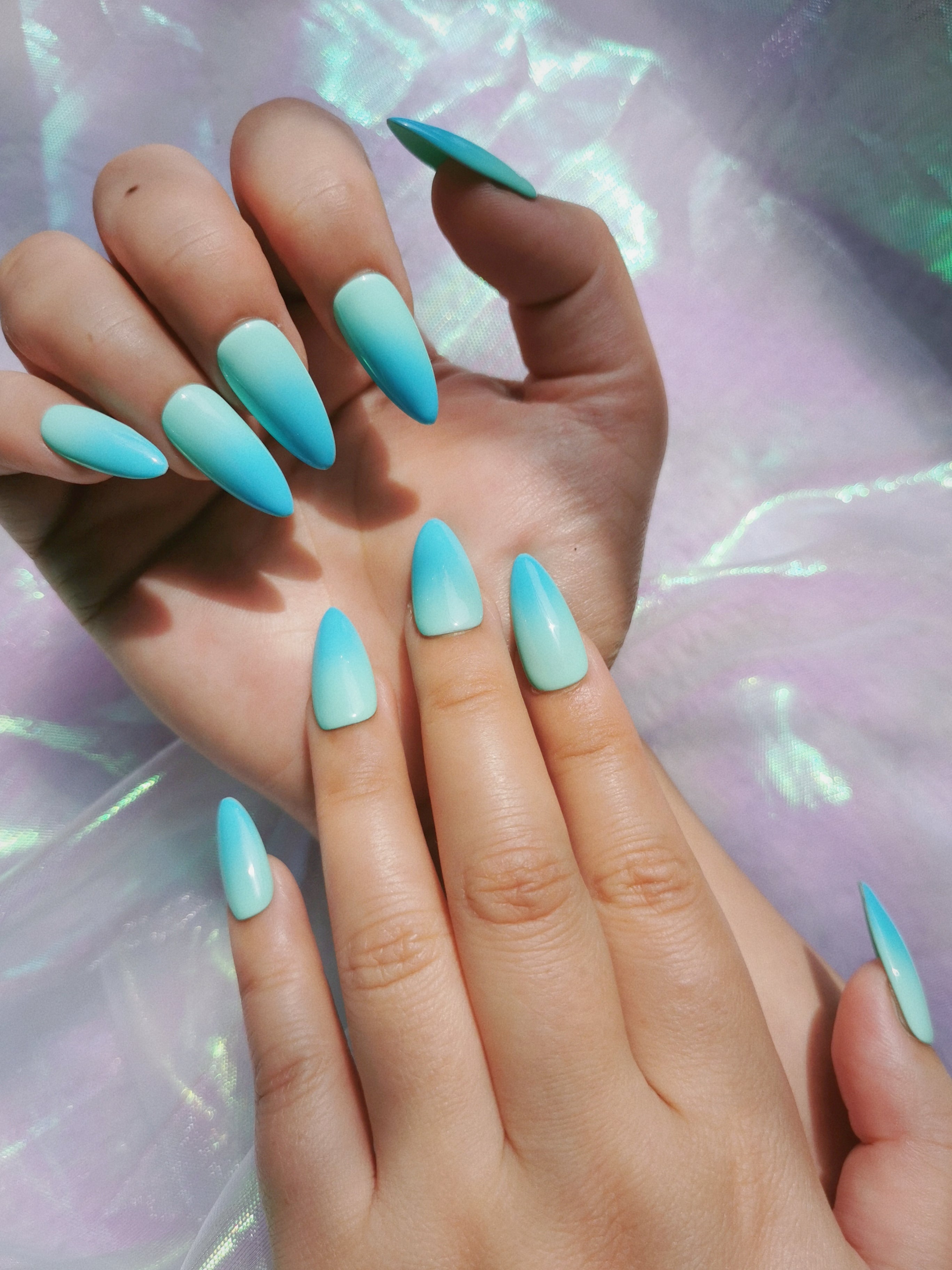 Hand wearing mint blue ombre almond press-on nails