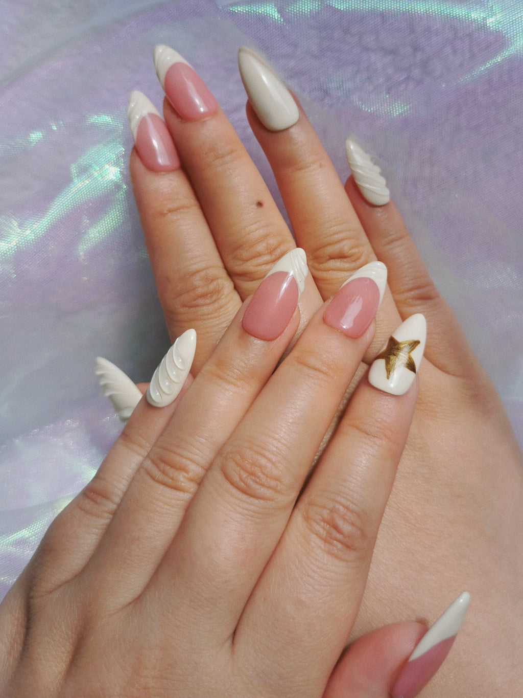 Top view of blush and milk white almond nails with raised sculpted details