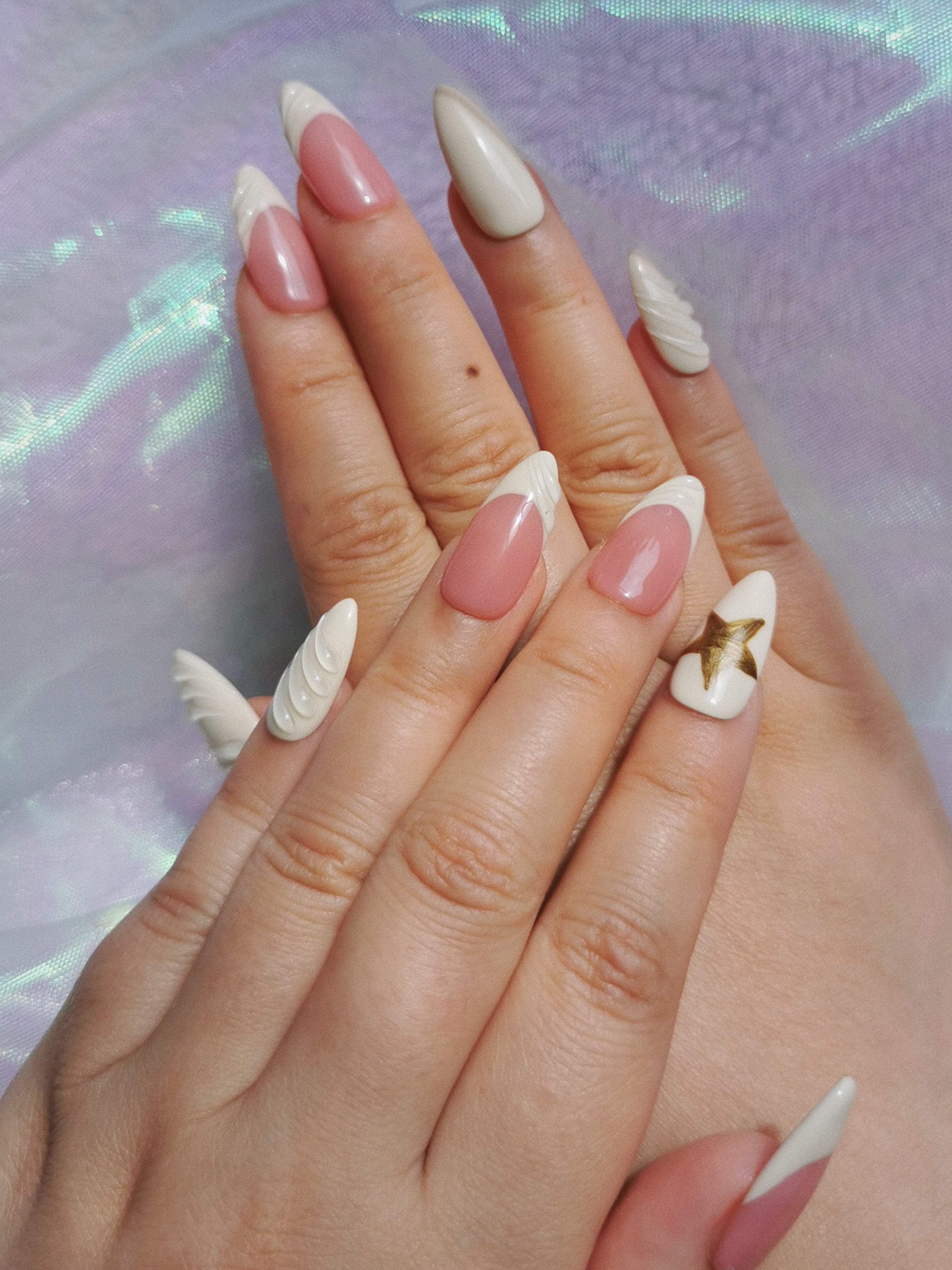 Top view of blush and milk white almond nails with raised sculpted details