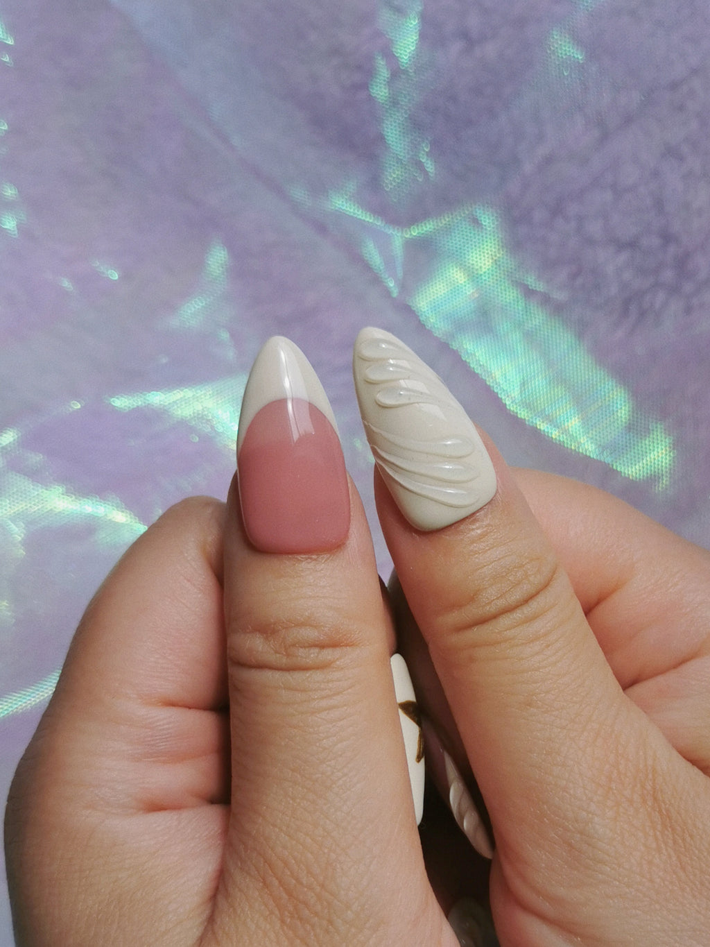 Close-up of glossy blush French tips and milk white sculpted nail texture