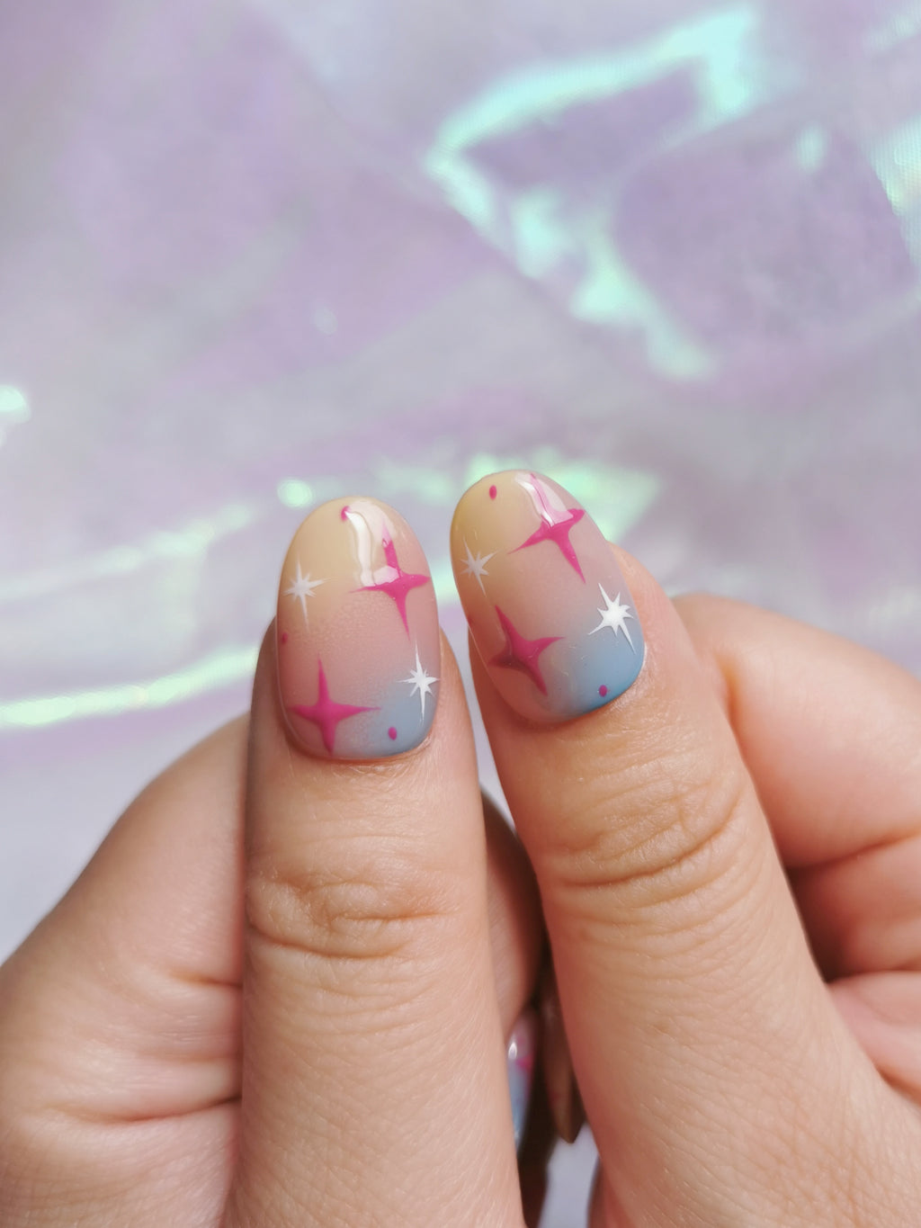 Detail view of two Y2K gradient nails with pink and white stars